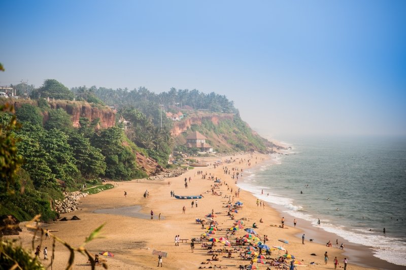 Steep cliffs rise above a beach next to the ocean.