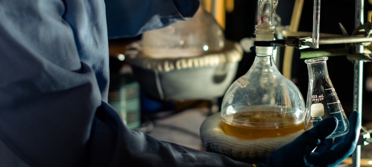 Technique videos, single-serving containers, tight scheduling and Shel Silverstein poems got instructors and students in the Department of Chemistry through the 2020-2021 academic year. Gloved hands hold a bottle with clear liquid.