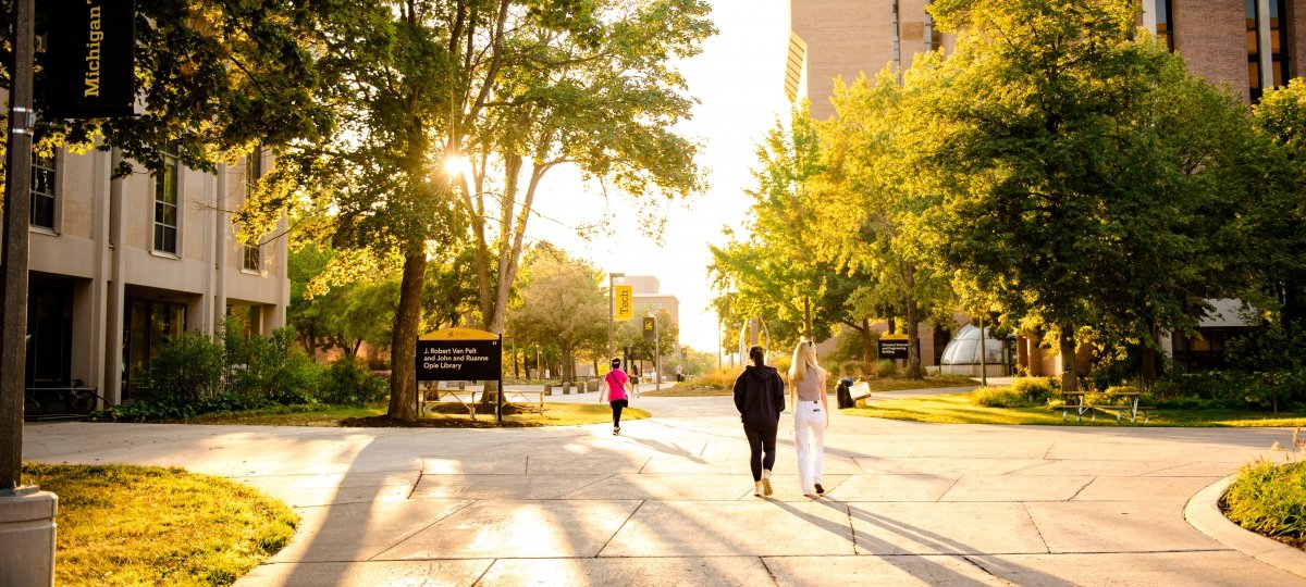 Students walk across the Michigan Tech campus as the sun sets