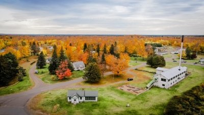 The Michigan Tech Ford Center, a collection of buildings used for teaching and lodging, surrounded by trees with golden and red leaves.