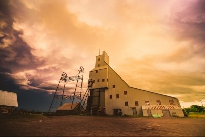 The Quincy mine headframe with a cloudy, sunset sky in the background.