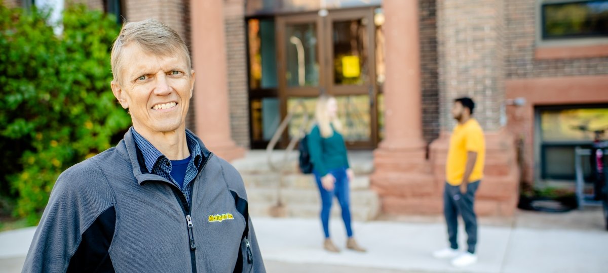 Jon Leinonen stands outside the College of Business at Michigan Tech.