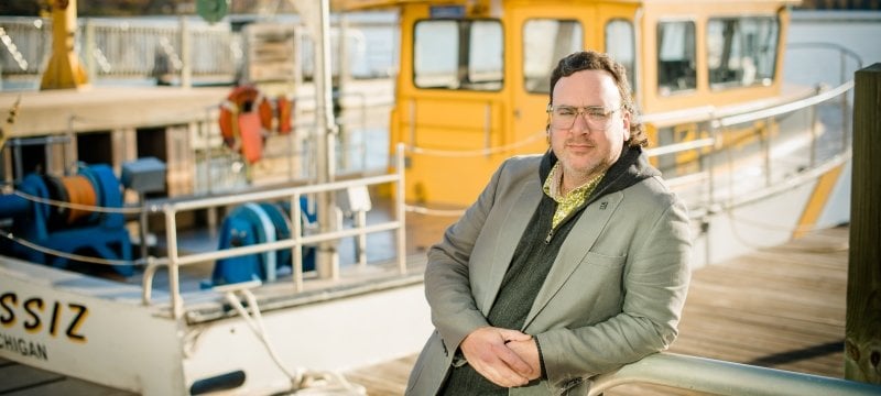 Tim Havens stands next to the research vessel Agassiz outside the Great Lakes Research Center