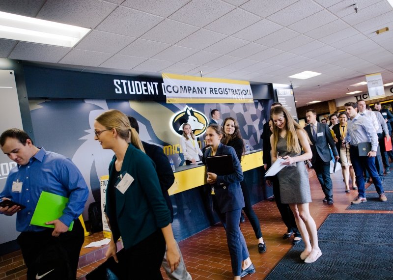 Students in suits, dresses, and other business attire line up in the student development complex at Michigan Tech for Career Fair events.