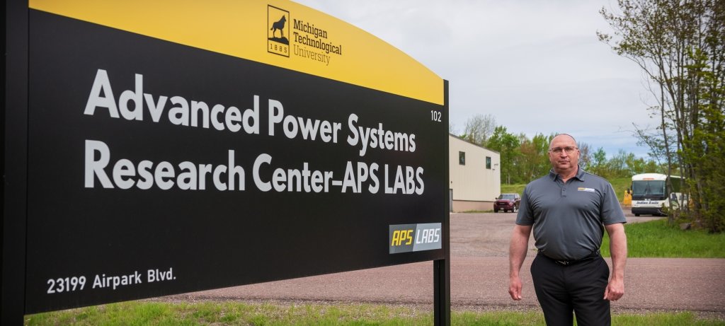 The 2022 Michigan Tech Research Award Winner stands in front of the APS LABS sign outside one of the research facilities he oversees.