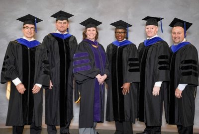 eight board members in caps and gowns at Michigan Tech commencement. Third from left is Brenda Ryan, the 2022 midyear commencement speaker.