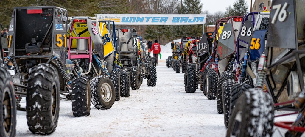 Racers in student-built off-road vehicles line up for the start of the 2023 Baja Blizzard Winter Invitational. (Image credit: Mackenzie Johnson) Baja off-road racing vehicles designed and built by students line up at a snowy starting line on an invitational course at Michigan Technological University
