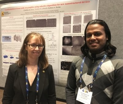 A researcher and her student at Michigan Tech stand before a poster at a conference sharing their surface science measurement findings.