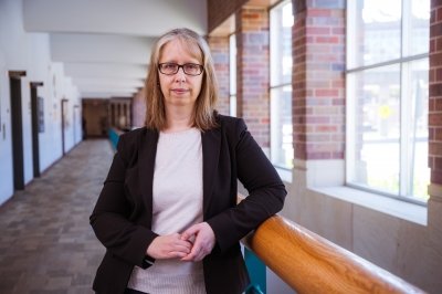 An award-winning Michigan Tech researcher stands in the hallway near her chemistry lab.