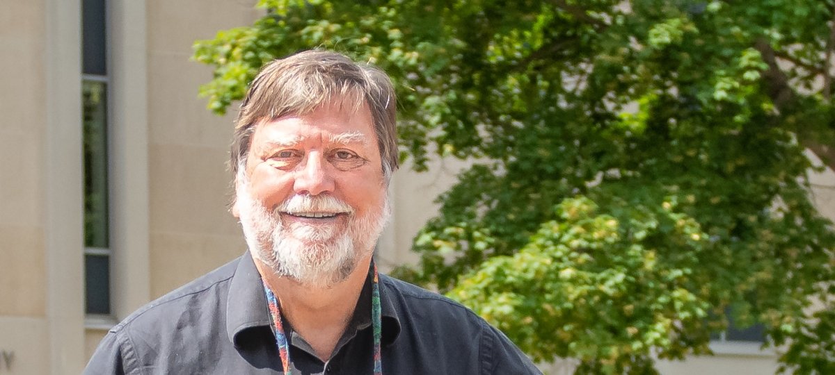 Michael Mullins smiling in front of library