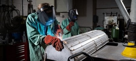 PSTDL researchers Hunter McGillivray and Collin Miller '22 weld liquid nitrogen lines onto a custom thermal shroud designed to simulate conditions in the permanently shaded regions of the moon.