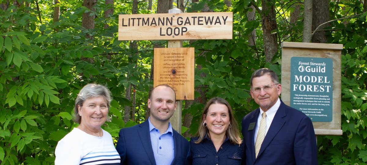 The Littmann family stands in front of a sign that says Littmann Gateway Loop