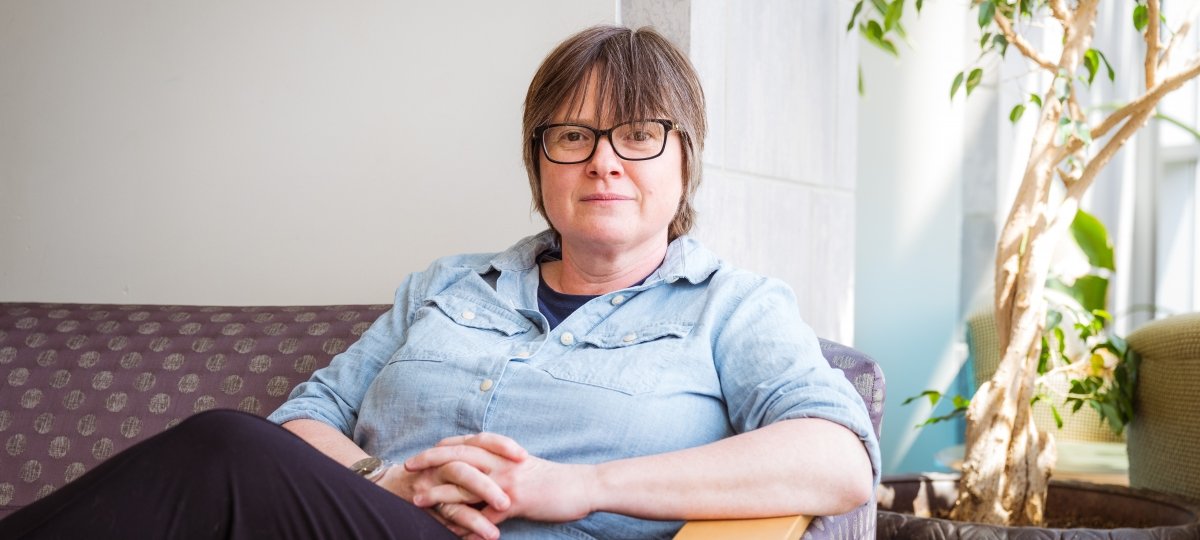Award winner Petra Huentemeyer, a Michigan Tech physicist, in a portrait sitting on a couch on campus as she shares her work in particle astrophysics in this research profile on Michigan Tech News.