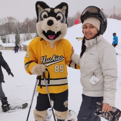 A graduate student enjoys Michigan Tech's Mont Ripley Ski Hill with university mascot Blizzard T. Husky