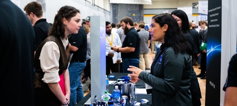 A Michigan Tech student talks to a recruiter at Career Fair, where thousands of interviews will be landed as students and companies meet.