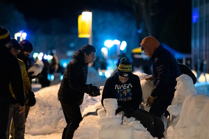 A student team works on their 2023 snow statue during all-nighter on the Michigan Tech campus.