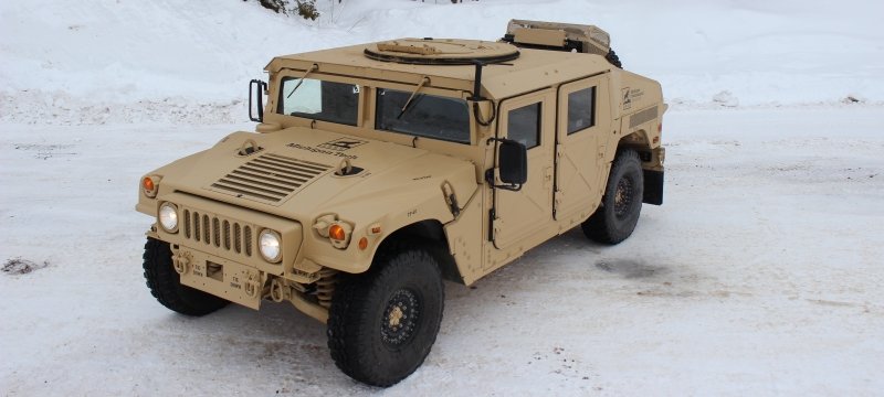 High-mobility multipurpose wheeled vehicle pictured from above in snow-covered lot. 