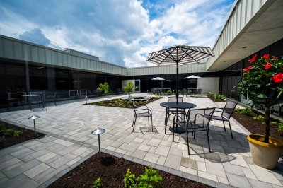 Open, sunlit courtyard with patio tables
