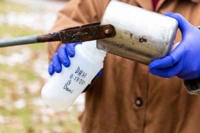 Student collects wastewater sample on MTU campus
