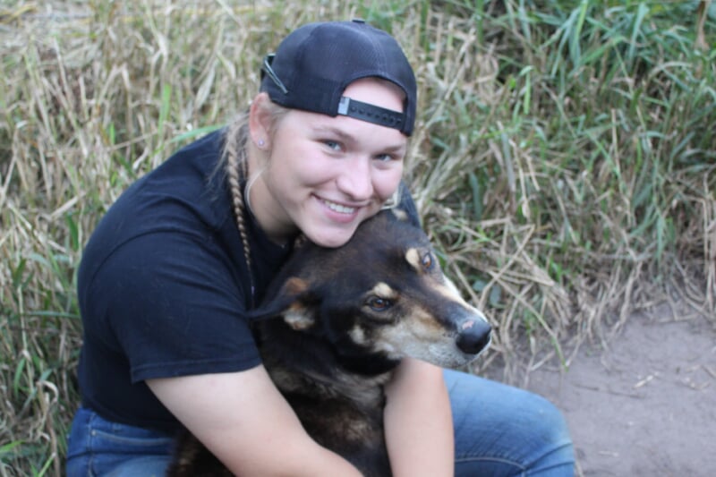 Brynn Santi hugging one of the mushing club dog.