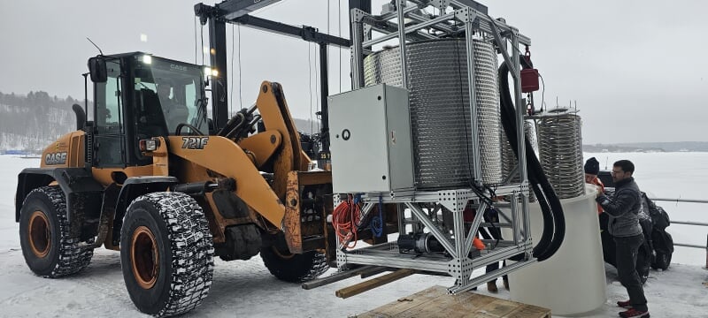 Front-end loader lifting the power station on a snowy day.