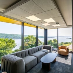 Community lounge in East Hall with modern seating and large windows overlooking the Portage Canal.