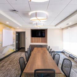 Study room in East Hall with a long conference-style table, chairs, whiteboard, and wall-mounted TV.