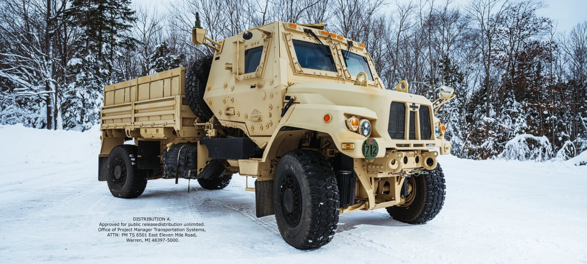 The tactical vehicles for the MEGA VIPK project include, but are not limited to, the latest Family of Medium Tactical Vehicles (FMTV) platform, like this FMTV A2. A large, tan-colored tactical vehicle stands parked outside in the snow.