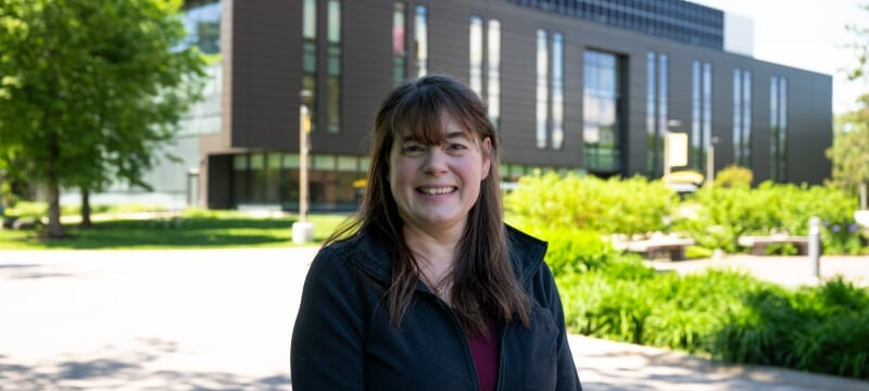 Kelly Kamm smiles outdoors on a sunny day on Michigan Tech’s campus.
