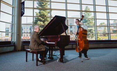 Dan Fuhrmann playing piano and Tim Havens playing stand-up bass in the Rozsa lobby.
