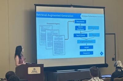 Jennifer Celeste stands at a podium in front of a presentation slide titled 'Retrieval Augmented Generation.'