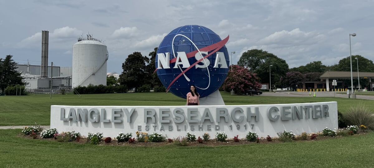 Jennifer Celeste stands in front of the large NASA globe statue at the NASA Langley Research Center.