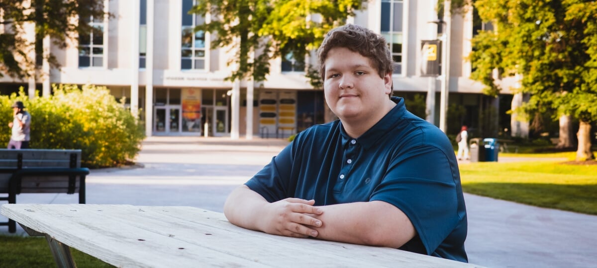 Second-year computer engineering student William Ingels is taking advantage of every opportunity that comes his way, both on campus and off. William Ingels sits at a picnic table wearing a blue polo in front of the Van Pelt and Opie Library.