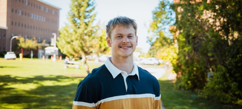 Jim Brisson standing on campus in early autumn.