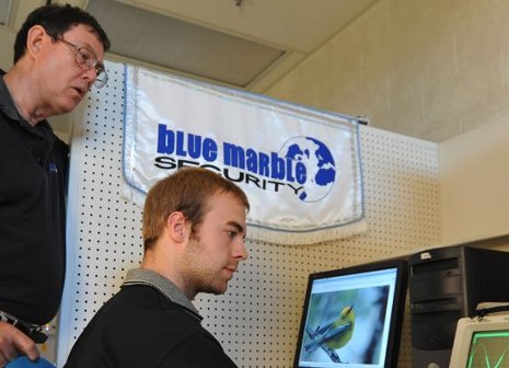 Teacher Glen Archer and student Casey Demars work on a project for Blue Marble Security Enterprise Team, summer 2009.