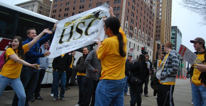 Michigan Tech students unfurl Undergraduate Student Government rally banner in Lansing.