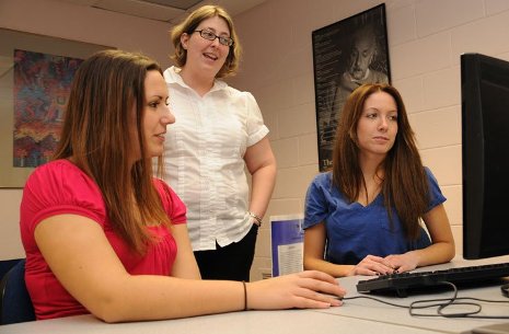Visiting assistant professor Leanne Forquer, standing, looks over the sleep research survey numbers with students Alison Greene, left, and Abrah Maki.