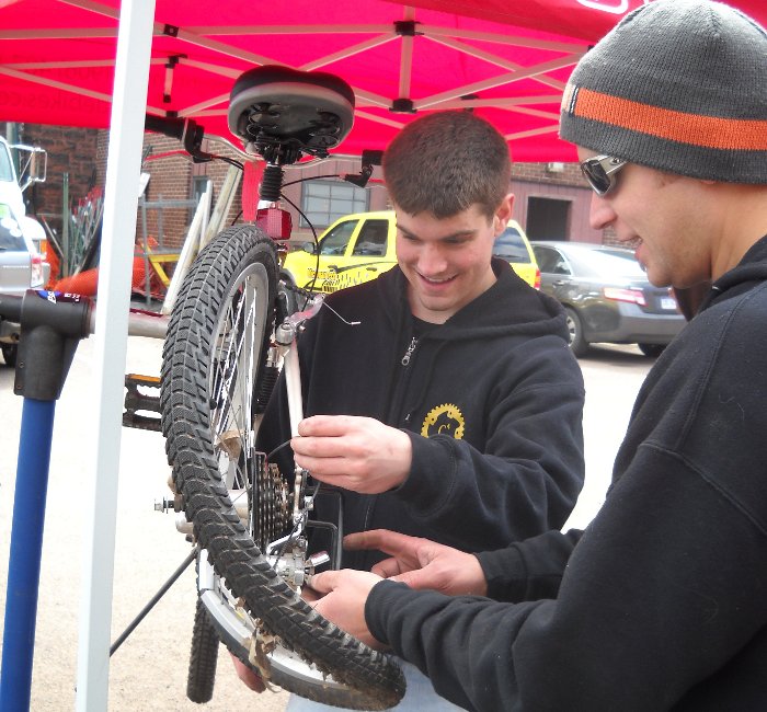 Caleb Wendel, Michigan Tech alumnus and owner of The Bike Shop,  and Kyle Bordeau, president of the Copper Country Cycling Club, work on an abandoned bike.