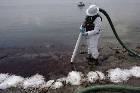 A worker uses a suction hose to remove oil washed ashore in Louisiana from the Deepwater Horizon oil spill.    Photo: Huffington Post 