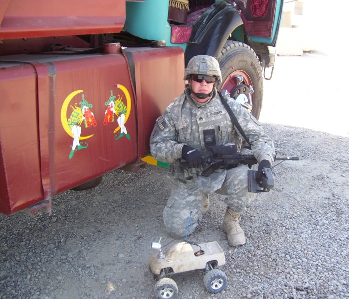 Staff Sgt. Chris Fessenden in Iraq with the radio-controlled truck his brother Ernie built to help him inspect vehicles