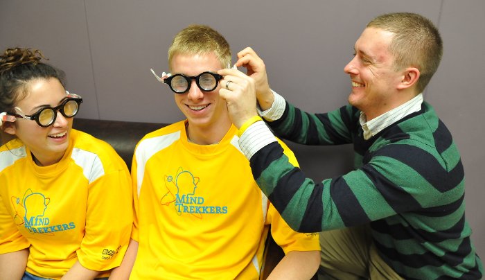 Cody Kangas, assistant director of pre-college outreach at Michigan Tech, fits Dow Corning self-adjusting eyeglasses on Mind Trekkers student volunteers, who will demonstrate the glasses and other science "magic" at the Einstein Science Expo in Green Bay.