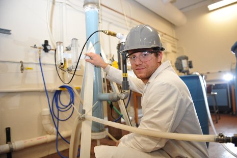 Chemical engineering PhD student Brett Spigarelli with his team's carbon dioxide scrubber. His prize-winning poster focused on improving the scrubber's efficiency. Sarah Bird photo