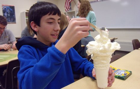 An 8th-grade Hancock Mind Trekker watches a "foam gnome" grow out of a two-polymer chemical reaction.