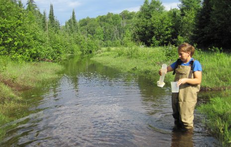 Undergraduate Faith Lambert sampling Hills Creek water upstream of the main restoration site.