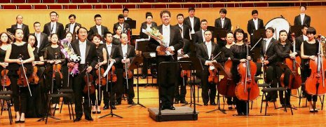 Joel Neves and the Hubei Symphony acknowledge the audience at Qintai Concert Hall in Wuhan, China following a concert in June. 