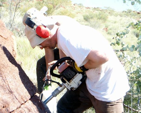 Aleksey Smirnov drills  into an outcrop in Australia's Widgiemooltha dike swarm. 