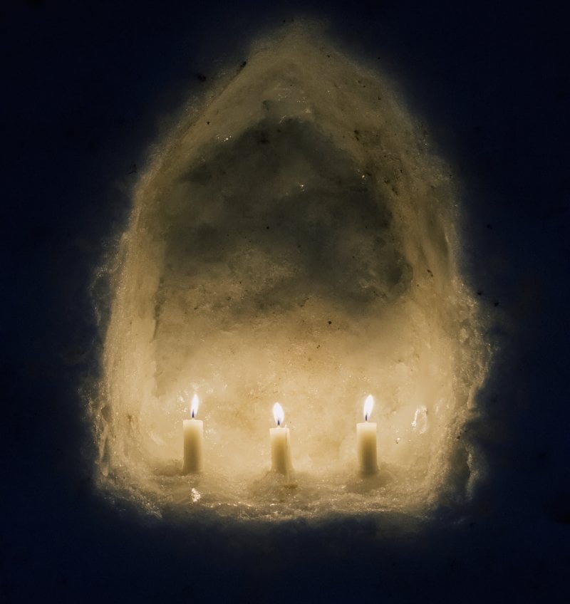 candles in an arch made of snow