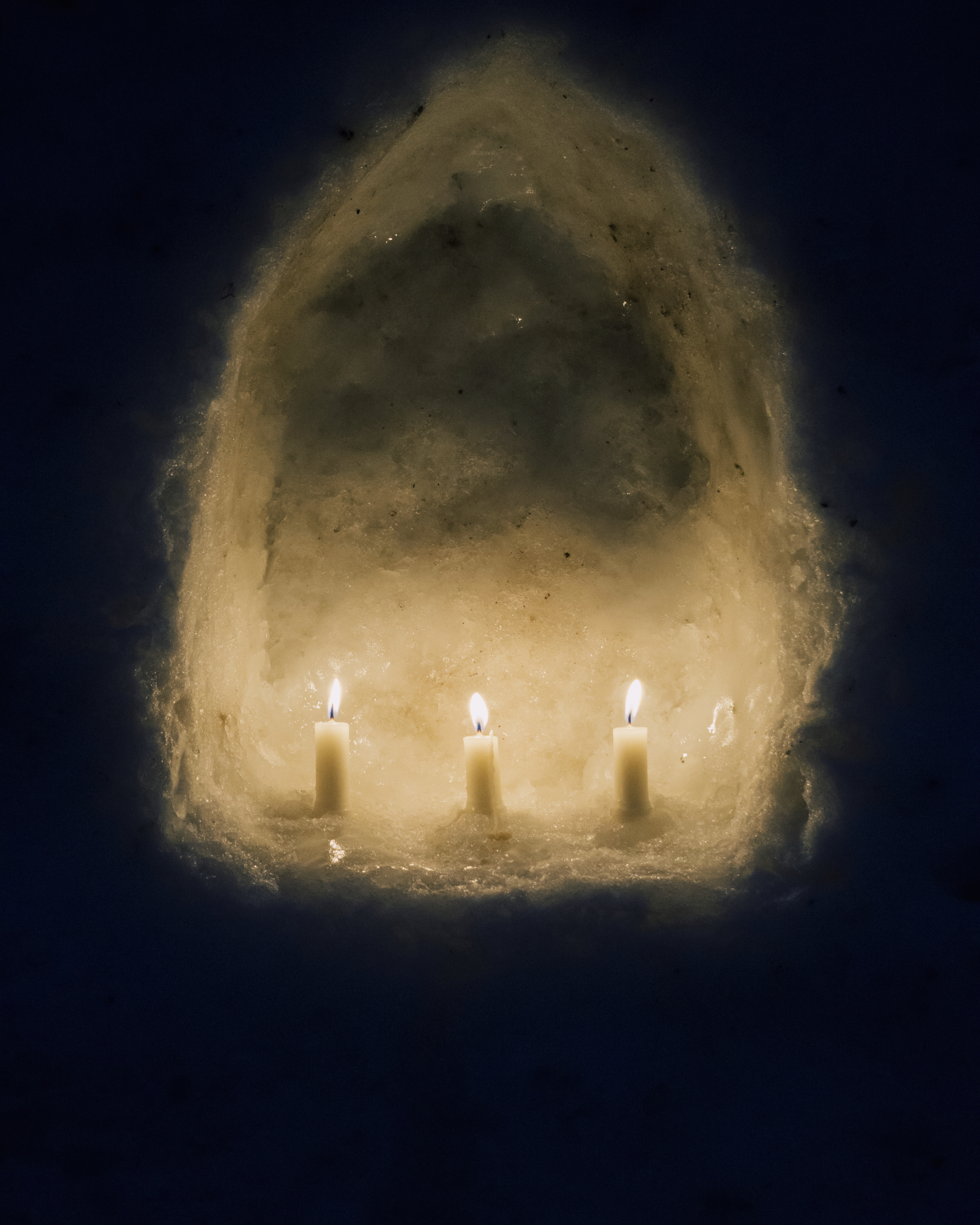 candles in an arch made of snow