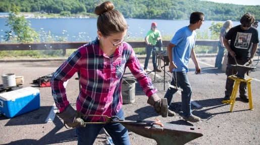 Summer Youth Programs student learning about what blacksmiths do.