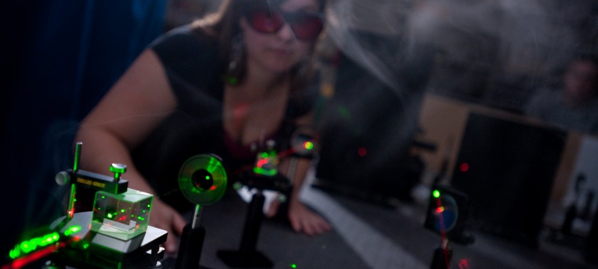 Researcher with goggles looking at lasers